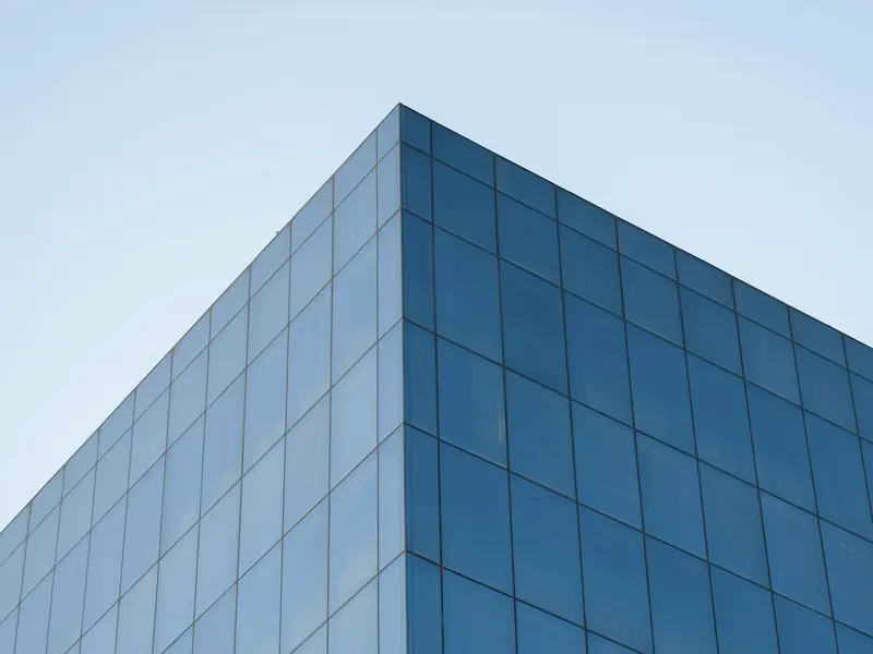 Corner of a modern blue glass office building